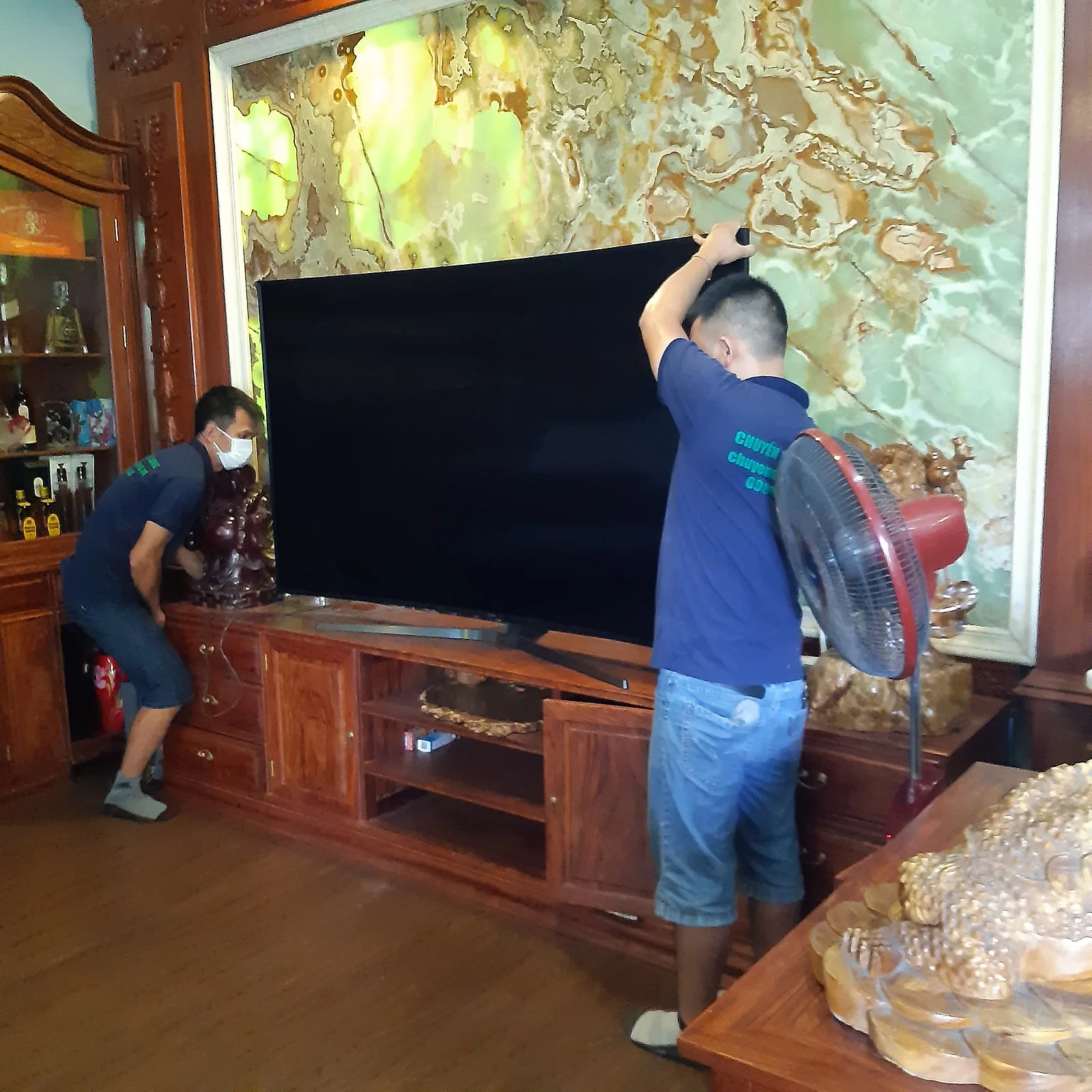 Thợ tháo tivi treo tường trước khi chuyển nhà