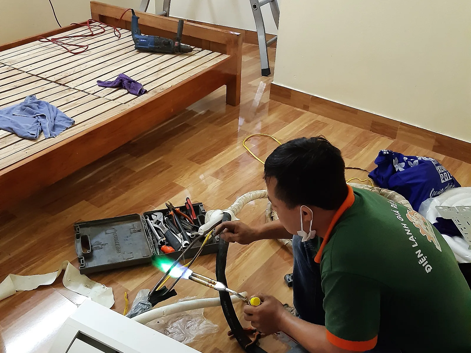 Thợ điện lạnh tháo dàn lạnh điều hòa trong phòng ngủ