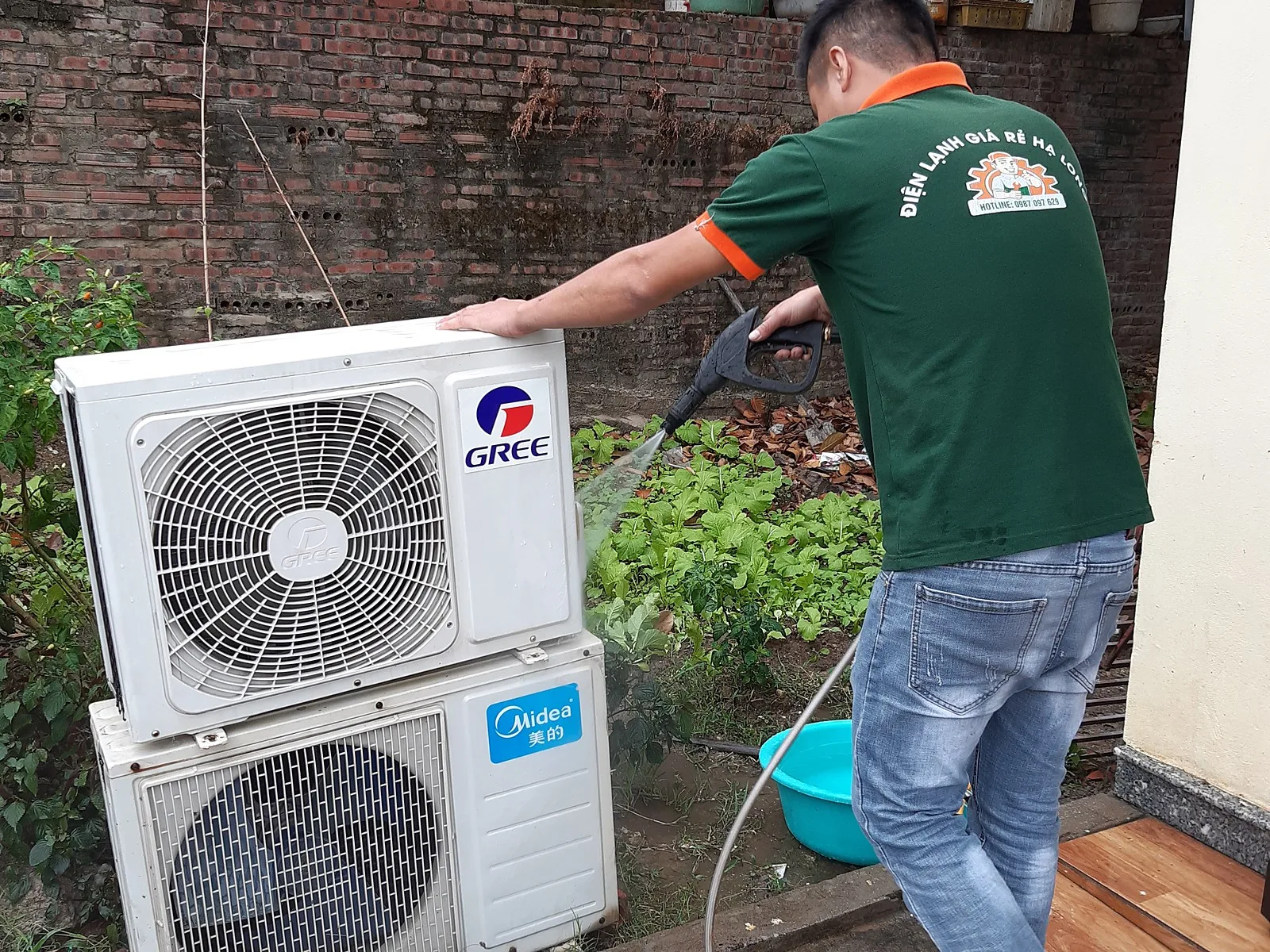 Thợ điện lạnh xịt rửa cục nóng điều hòa trước khi lắp lại