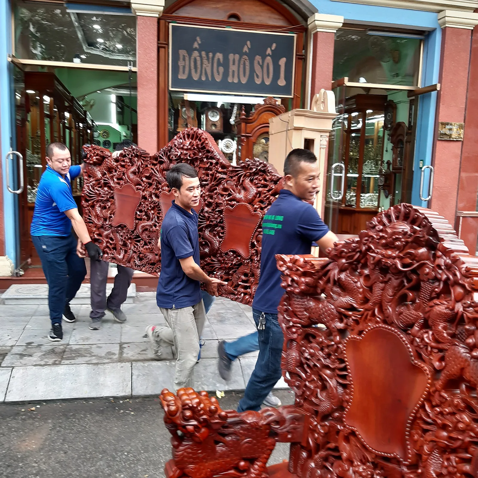 Thợ khiêng bộ bàn ghế gỗ đục cỡ lớn