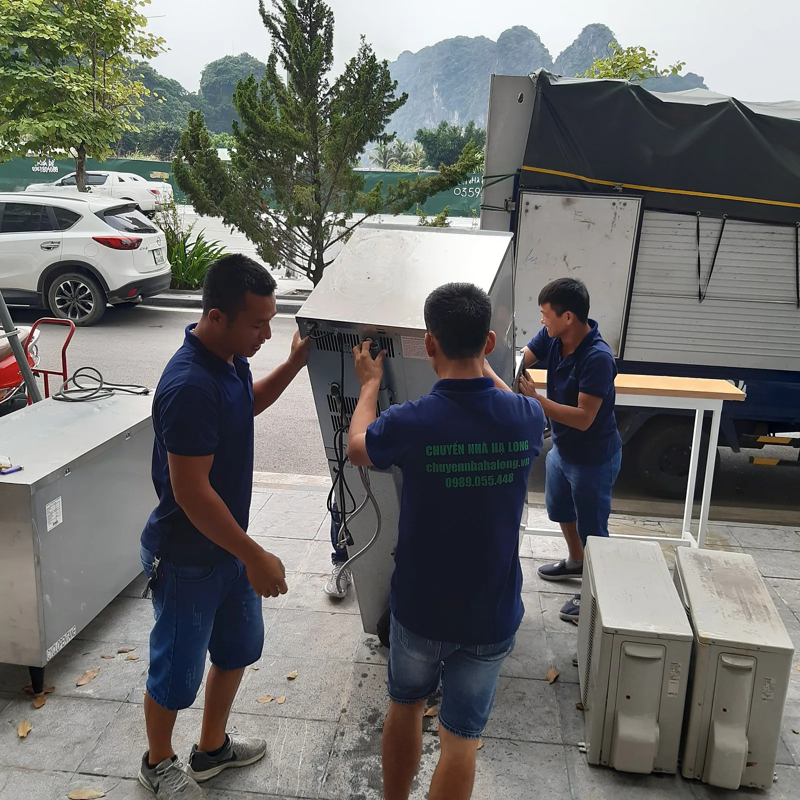 Thợ khiêng thiết bị bếp inox lên xe tải